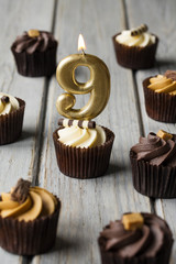 Number 9 celebration birthday cupcakes on a wooden background