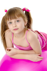 little girl doing exercises on a big ball for fitness.