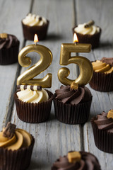 Number 25 celebration birthday cupcakes on a wooden background