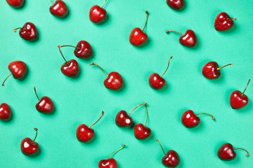 Naklejka na ściany i meble Cherries on green background