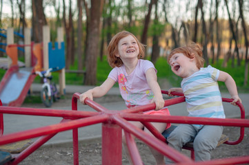 Fototapeta na wymiar Children ride on a swing, delight