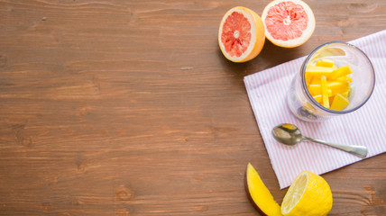 fresh smoothies in glass glass with banana, orange, mango, on wooden background.