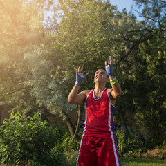 Young athlete performs sports exercises with a ball outdoors.