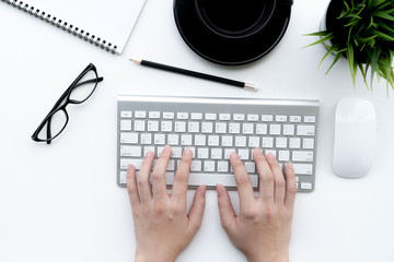 Flat lay of top view Business woman use keyboard on modern white desk work table with computer laptop and stationary in home office includes copyspace for add text or graphic