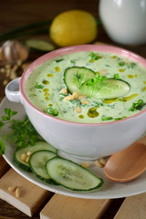 Cold soup Tarator with kefir, cucumbers and pine nuts in a ceramic tureen. Bulgarian cuisine meal