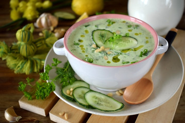 Cold soup Tarator with kefir, cucumbers and pine nuts in a ceramic tureen. Bulgarian cuisine meal