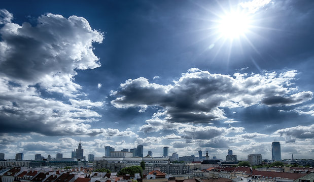 Panorama of Warsaw with dark clouds and sun