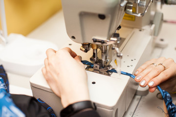 close up Tailoring Process - Women's hands behind her sewing.