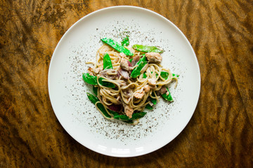 Paste. Italian cuisine, cooked dish on an old background. concepts old recipe. idigrants sauce, spices, peas, young, onion, red onion with pasta