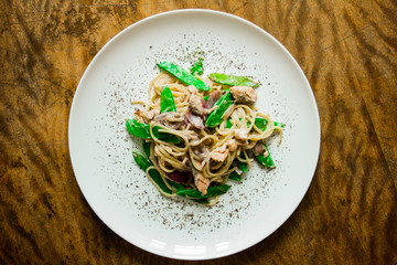 Paste. Italian cuisine, cooked dish on an old background. concepts old recipe. idigrants sauce, spices, peas, young, onion, red onion with pasta