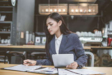 Portrait of smiling pretty young business woman in glasses sitting on workplace