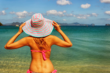 Young beautiful girl body on a blue sky background and the sea on the beach. Time for rest, happy way of life. Holidays in the Philippines, Elnido, nature reserve.