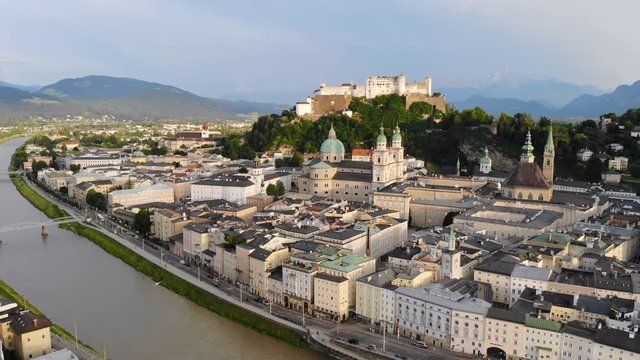 Aerial panoramic view of cityscape of Salzburg city, Salzach River, Salzburg Cathedral, old historic Fortress Hohensalzburg and Alps mountains in backgroung - landscape of Austria from above, Europe