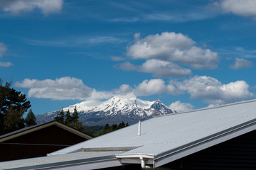 Snowy mountain in view behind roofing