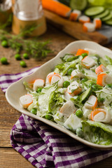 Crab sticks salad with peas, cucumber and mayonnaise.