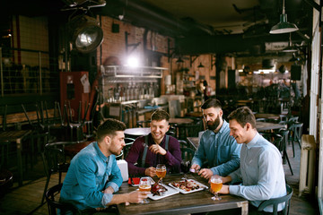Fototapeta premium Mężczyźni W Pubie Pije Piwo I Je Jedzenie