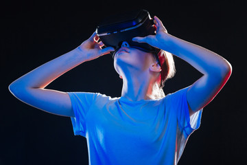 VR concept. Smart young woman using VR glasses while testing new technology