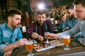 Men In Pub Drinking Beer And Eating Food