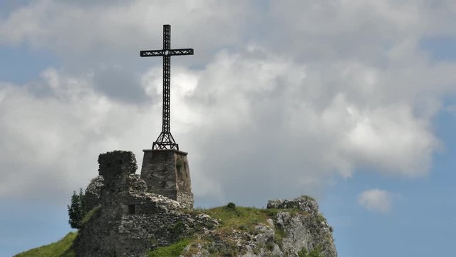Time lapse - Christian cross erected on a rock against cloudy sky. Shot in Pennabilli, Italy