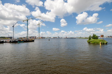 Fototapeta premium Start of the construction of new appartments at the side of het IJ, seen from the Silodam Amsterdam, the Netherlands