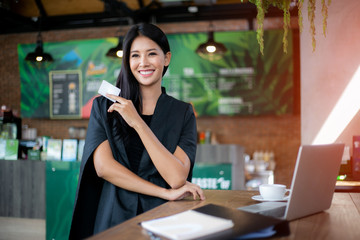 Young woman holding credit card and using laptop computer. Online shopping concept