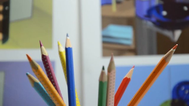 Rotating colored pencils in designer studio, closeup.
