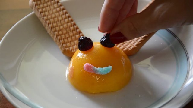Preapering interesting and funny meal for children, using peaches, biscuits and some candy for desert.
