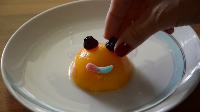 Preapering interesting and funny meal for children, using peaches, biscuits and some candy for desert.