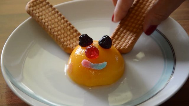 Preapering interesting and funny meal for children, using peaches, biscuits and some candy for desert.
