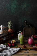 Organic fruit smoothies with fruits in mess on wooden background