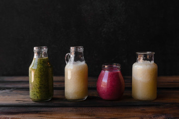 Set of bottles with fresh healthy smoothies on rustic table