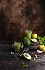 Organic smoothie on rustic table with fruits and herbs