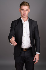 Fototapeta premium Young handsome businessman with blond hair wearing suit against 