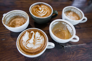 Coffee workshop top view of Coffee cup with latte art on wooden table . Selective focus white cup.color vintage style.