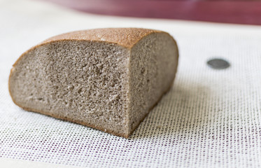 A piece of black bread and coins. The concept of poverty, lack of money for food.