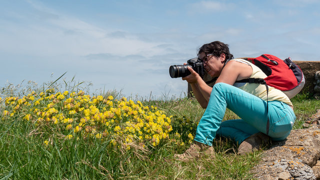 female photographer taking a photograph, outdoors