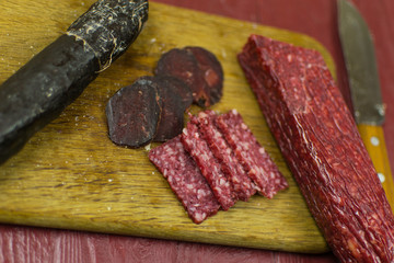 Smoked sausages are cut on a cutting board.