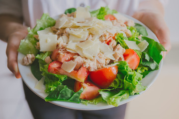 Girl holding healthy salad ready to eat