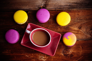 colored macaroons and a Cup of coffee on a wooden table, color macaroons ultraviolet