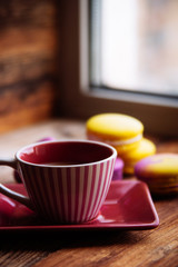 colored macaroons and a Cup of coffee on a wooden table, color macaroons ultraviolet