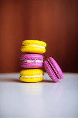 Vibrant colorful macarons on white wooden table. Text space