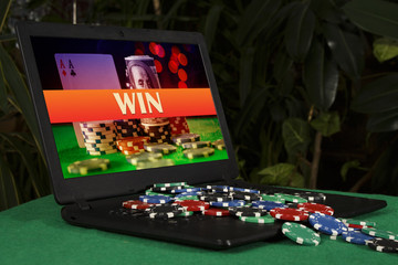Fototapeta premium A lot of poker chips on the laptop with the inscription 