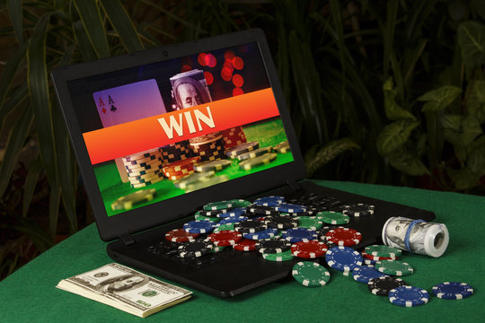 A lot of poker chips on the laptop with the inscription "win"