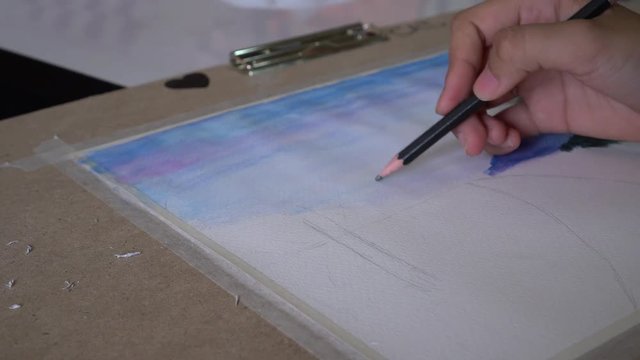 Student's hand with brush drawing on paper for creation picture abstract of watercolor painting with bamboo brush in Art subject classroom secondary education in Thailand