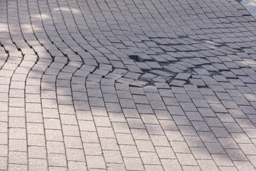 Einfahrt Betonpflaster Steine Verband ist verschoben im Schatten