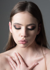 Obraz premium Makeup smokey eyes for model with soft skin. Fashion look concept. Beauty and hairdresser. Girl with pale face on grey background. Trendy woman with stylish hair and fashionable makeup.