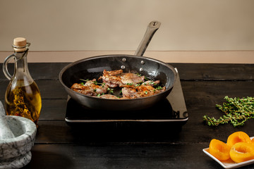 Roasted quail in a frying pan on wooden background