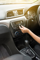 Hand  woman touching the screen and turning on car radio system,Button on dashboard in car panel