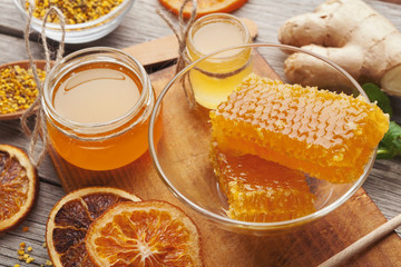 Various types of honey on wooden platter, closeup