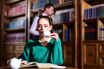 literature cafe with cute girl and man. woman in library read book at teapot drinking coffee from...